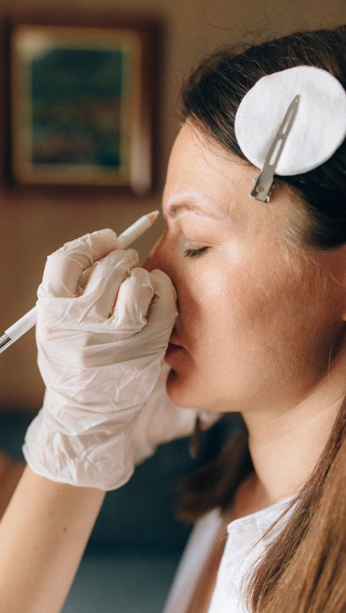 Brow being marked in white pencil before shaping at Erothots