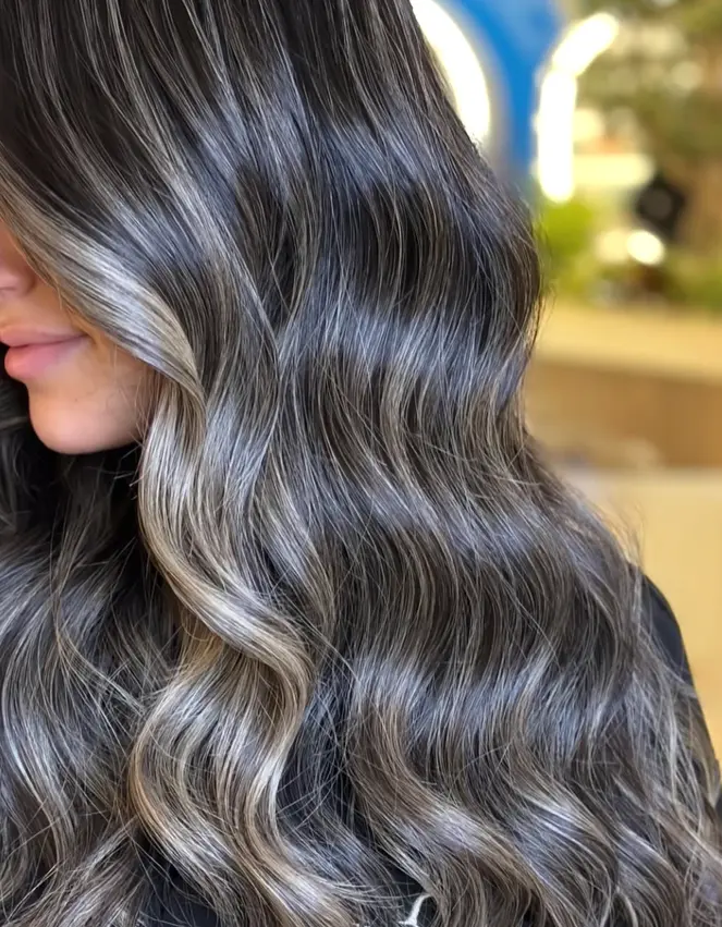 Lightener being hand painted onto a section during a balayage
